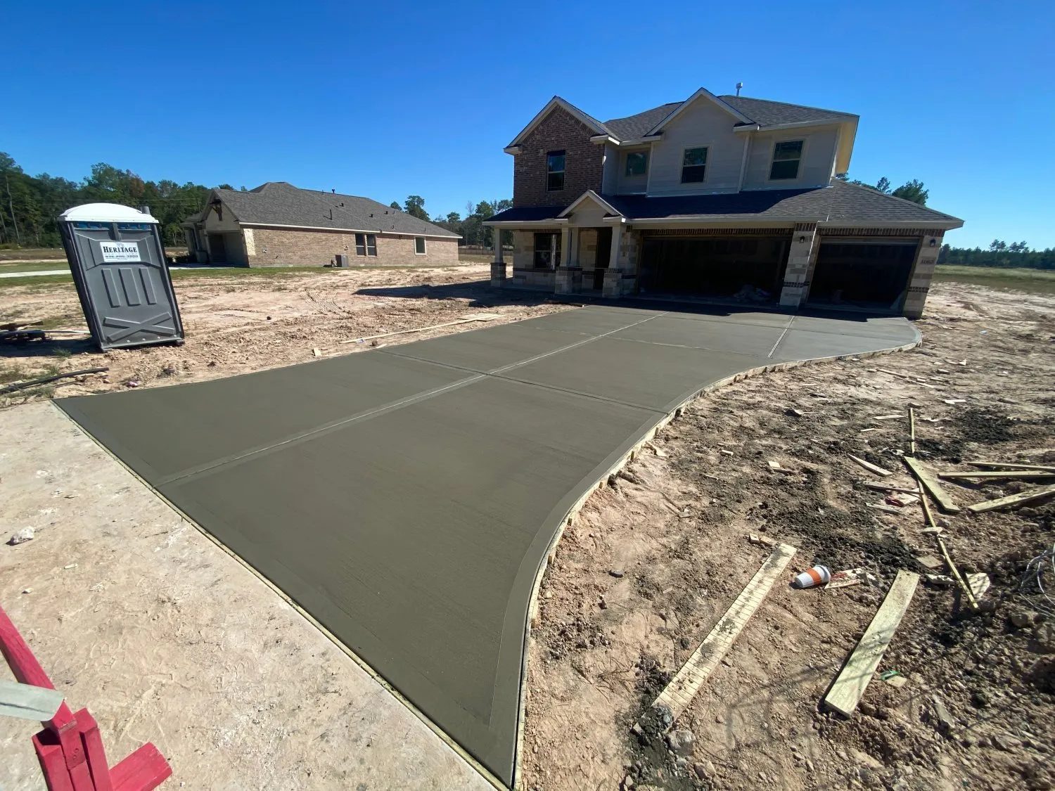 Fresh concrete driveway poured at a new construction home